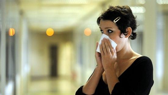 Illustrasjonsfotoet viser en kvinne som holder et tørkle foran nesen