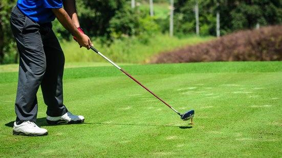 Illustrasjonsfoto: Vi ser beina, armene og golfkøllen til en mann som spiller golf.