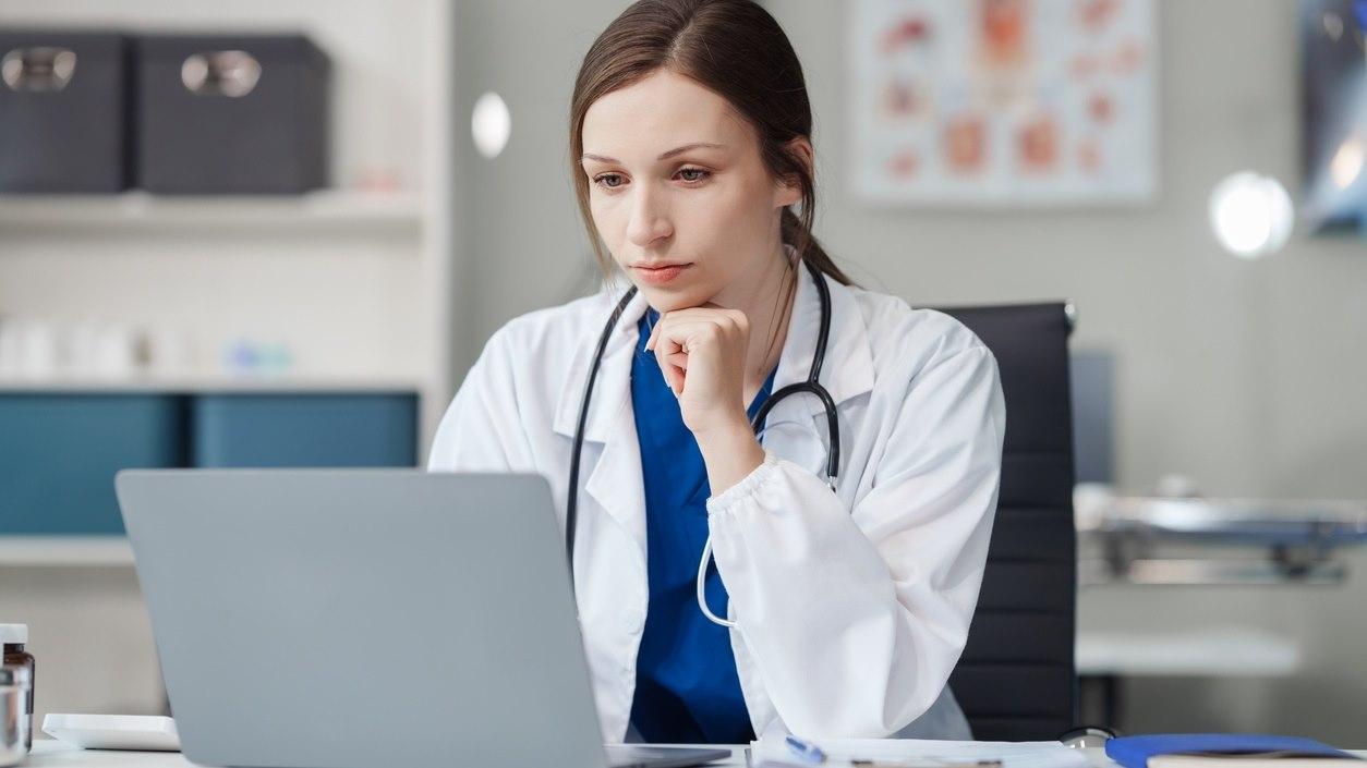 Illustrasjonsfotoet viser lege som sitter ved pc og tar kurs