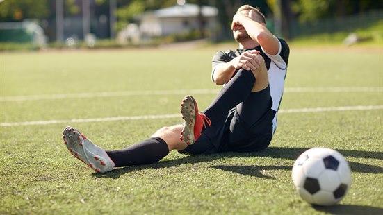 Illustrasjonsfotoet viser en fotballspiller som tar seg til kneet