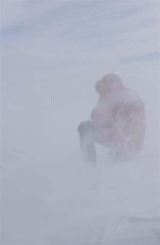 En som sitter ute i snøstorm