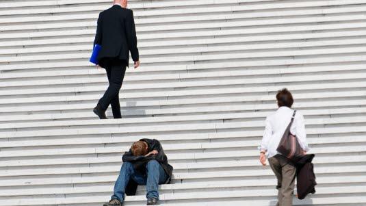 Illustrasjonsfoto viser en trapp der to mennesker er på veg opp, men en tredje sitter med hodet gjemt i armene sine.