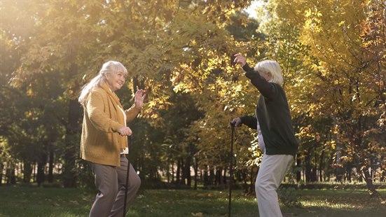 Illustrasjonsfoto av to eldre kvinner som danser i en park.