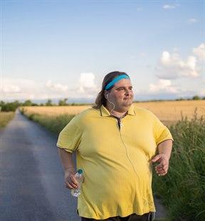 Illustrasjonsfoto viser en overvektig mann som går tur langs en vei