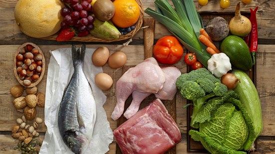 Illustrasjonsfoto av ei benkeplate med kjøtt, fisk, frukt, nøtter og grønnsaker