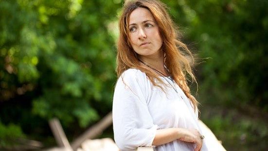 Illustrasjonsfoto av kvinne utendørs med et alvorlig ansiktsuttrykk.