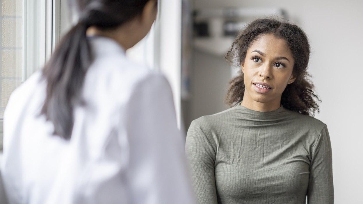 Illustrasjonsbilde viser en ung kvinne som er hos legen sin. Vi ser den unge kvinnen i fokus.