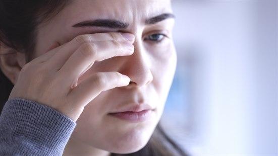 Illustrasjonsfotoet viser en kvinne som tar seg til det ene øyet