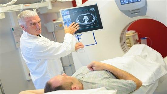 Lege viser MR-bilde til sengeliggende pasient med prostatakreft