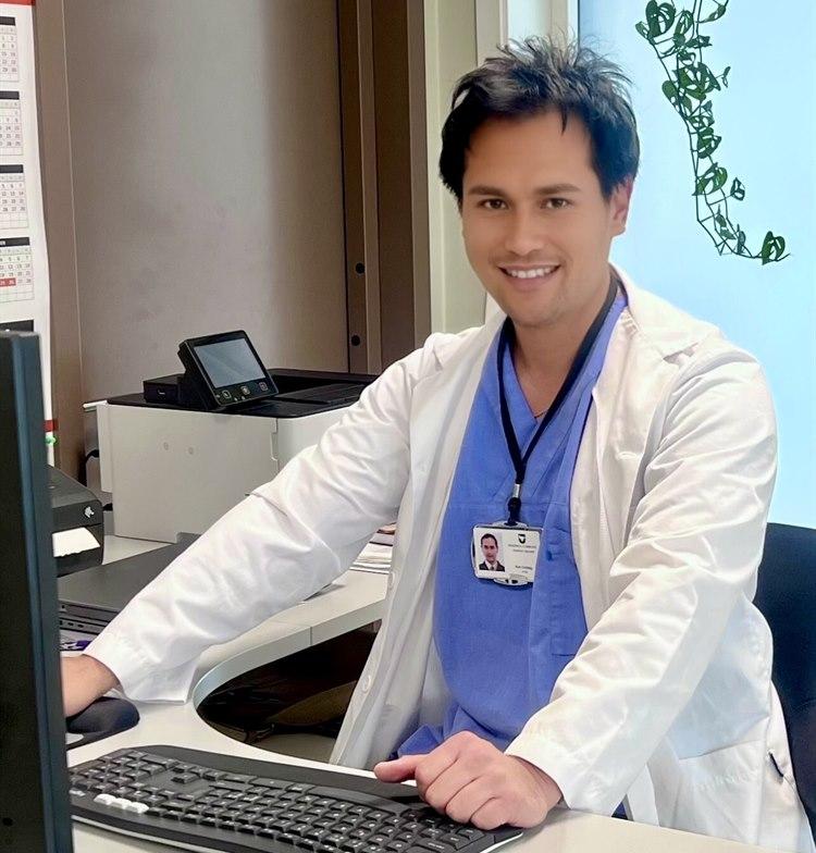 Illustrasjonsfotoet viser fastlege Aim Yap Undag som smiler på kontoret sitt