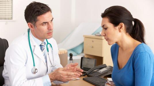 Illustrasjonsfotoet viser en kvinne som har en legekonsultasjon med en mannlig lege