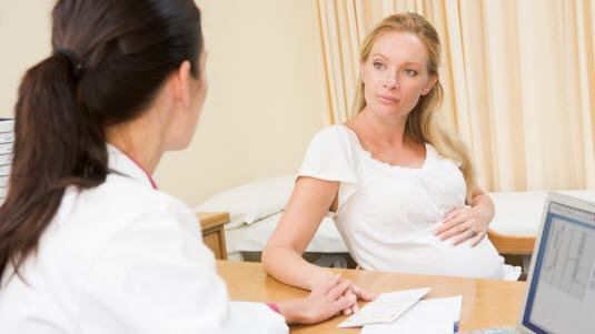 Illustrasjonsfotoet viser en gravid kvinne som sitter i en konsultasjon med lege