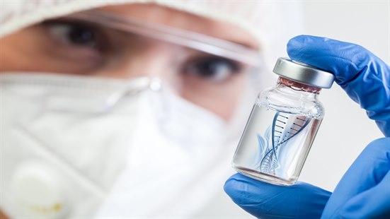 Forsker studerer et væskefylt hetteglass med dobbelttrådet RNA.