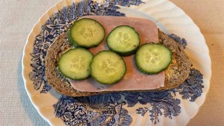 Foto av ei brødskive med skinke og agurk