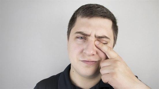 Illustrasjonsfotoet viser en mann som holder seg for det ene øyet