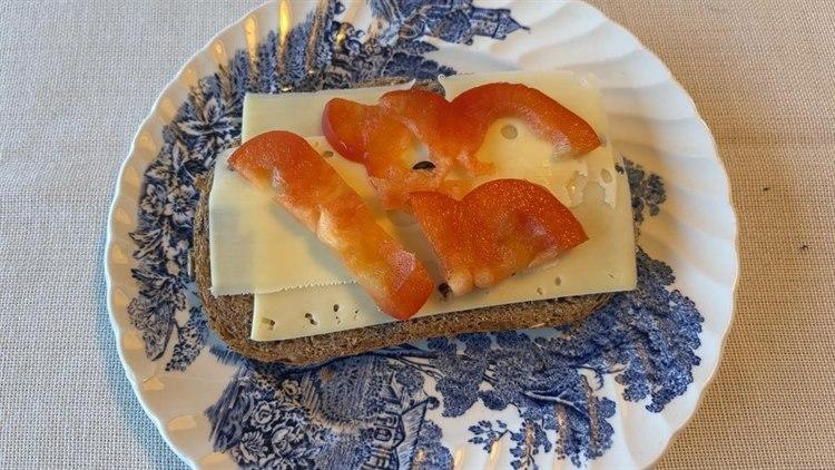 Foto av ei brødskive med hvitost og paprika