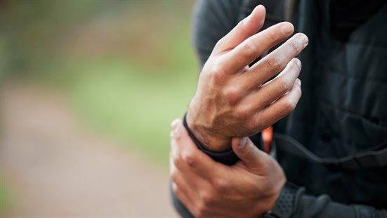 Illustrasjonsfotoet viser nærbilde av en person som holder seg mot håndleddet