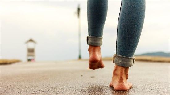 Illustrasjonsfotoet viser en person som går barbeint på en vei