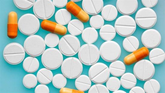 Illustrationsfoto som viser mange tabletter av ulik type mot blå bakgrunn.